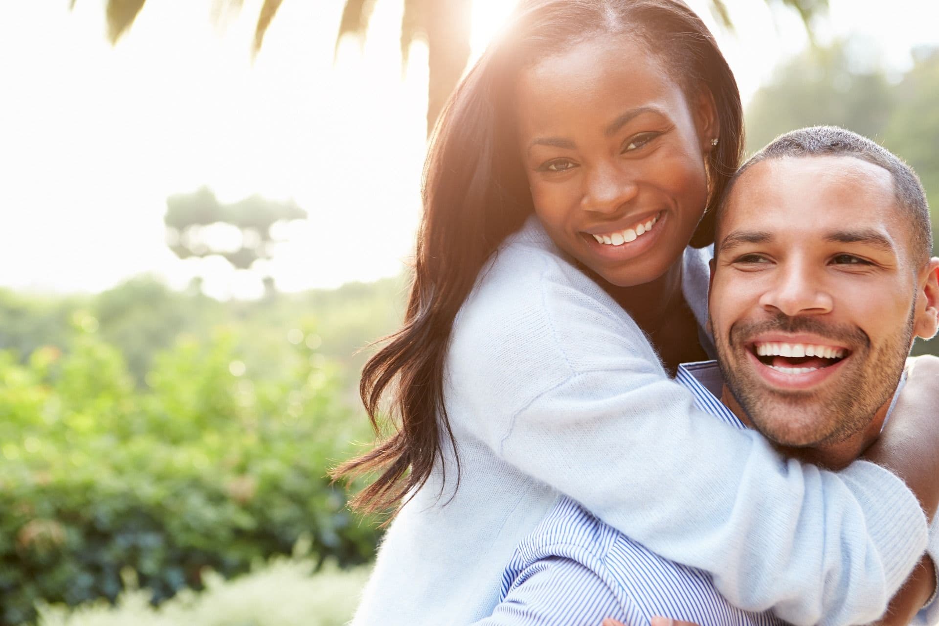 Couple hugging under a palm tree
