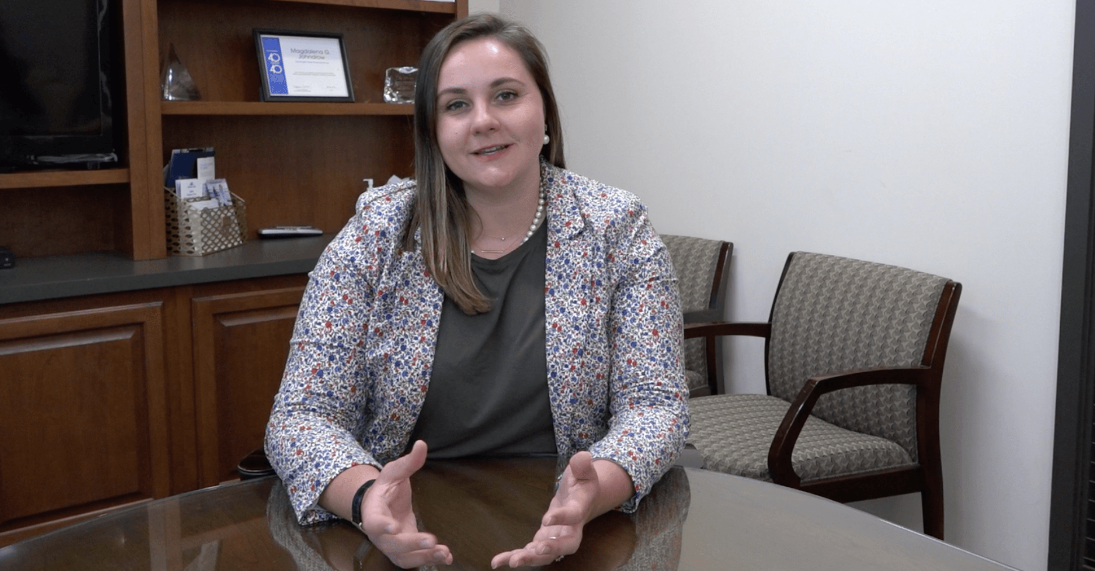 Maggie Johndrow of Johndrow Wealth Management sitting at a table in an office