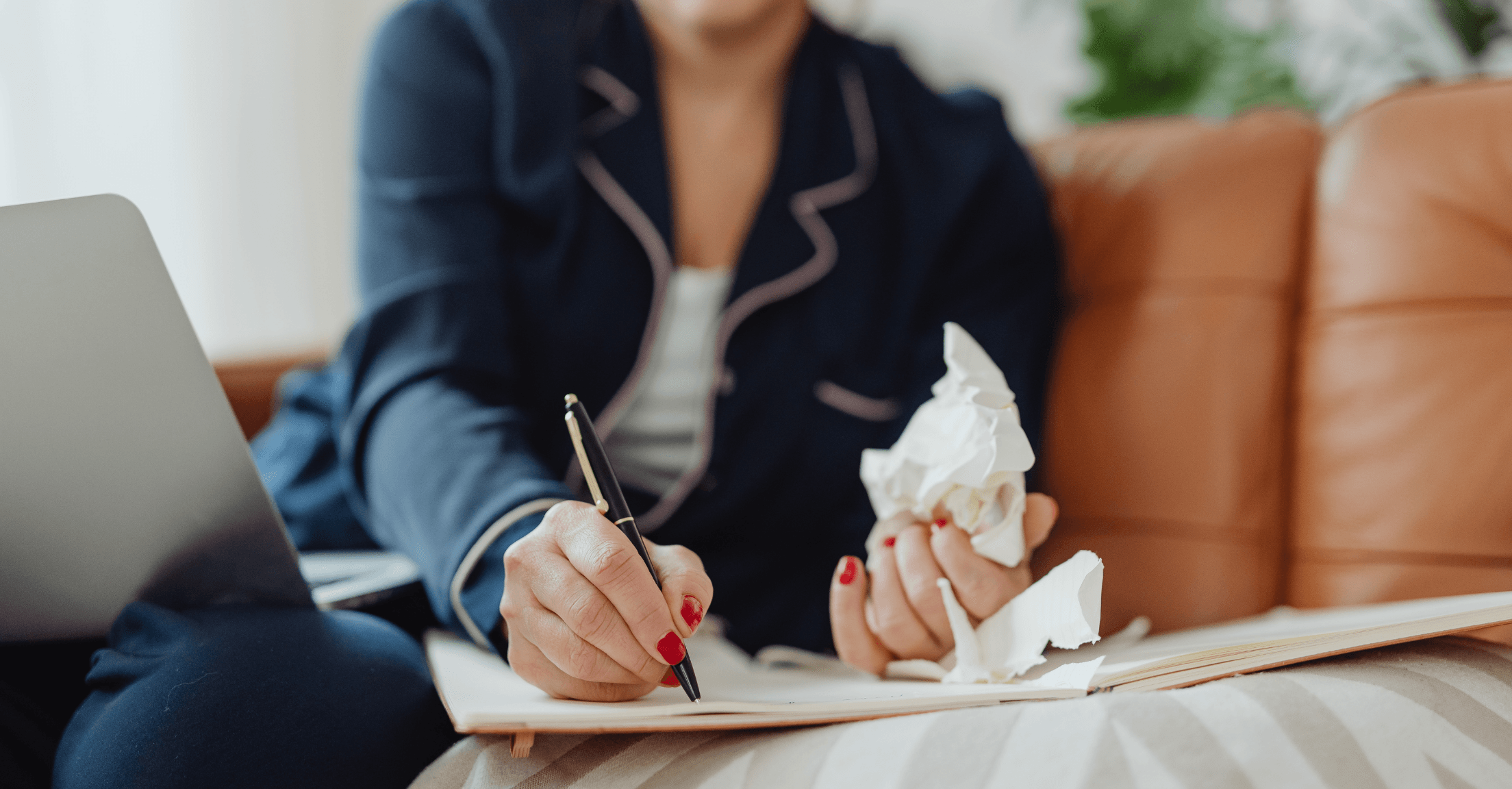 Woman working with pen and paper and crumbled up paper