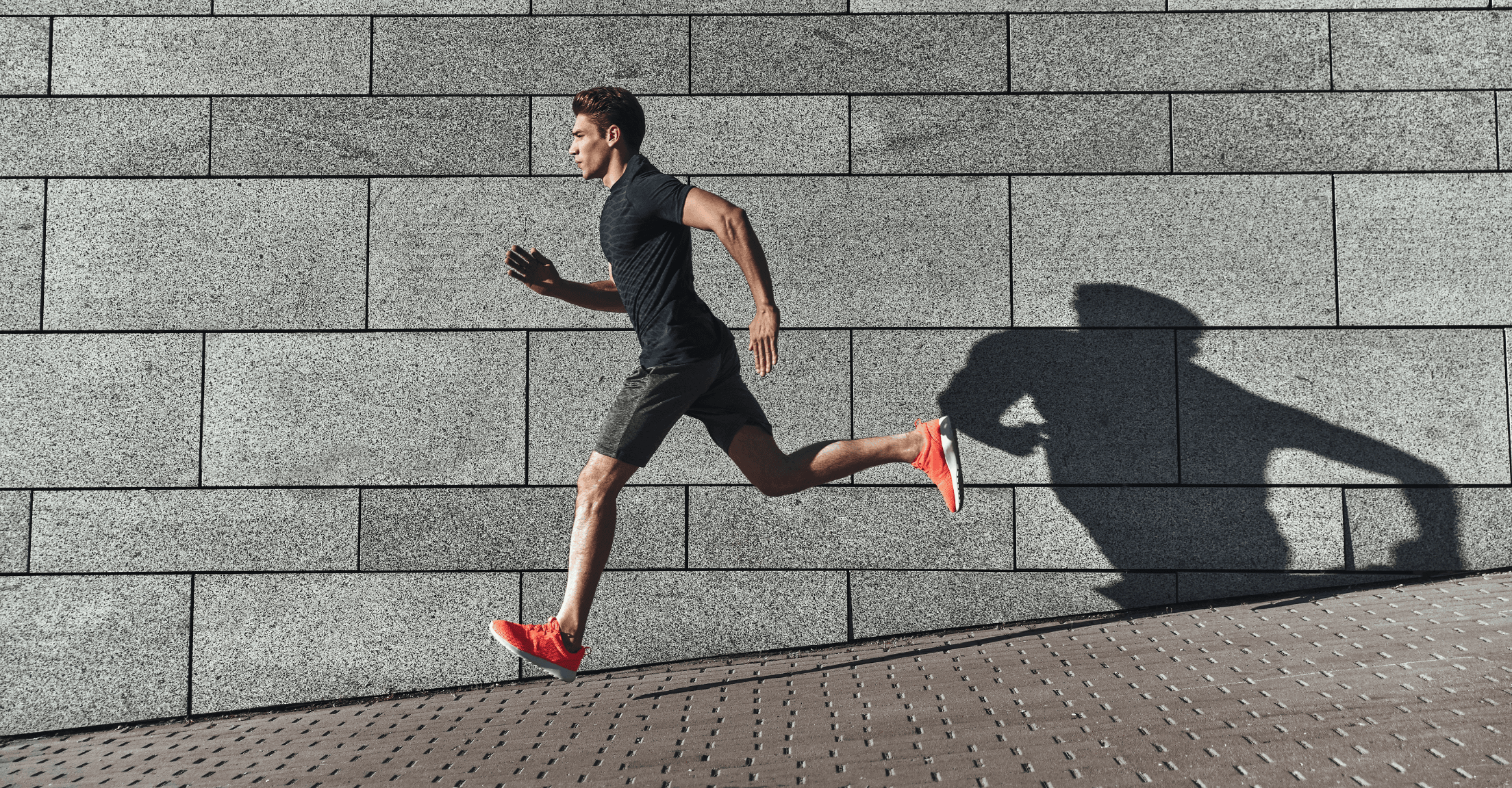 Man running on an inclined walkway against a wall