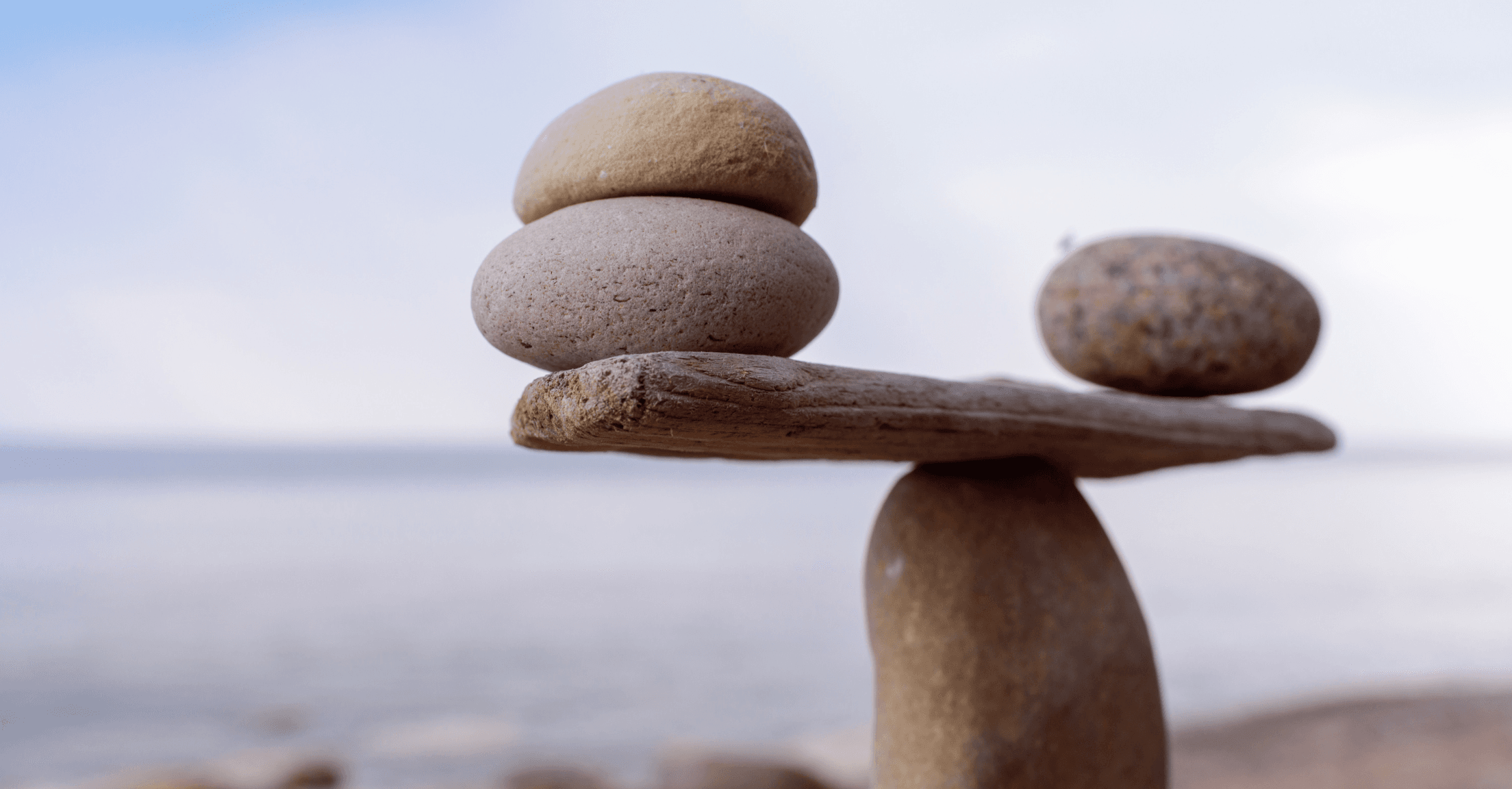 Rocks balanced on a board in front of water
