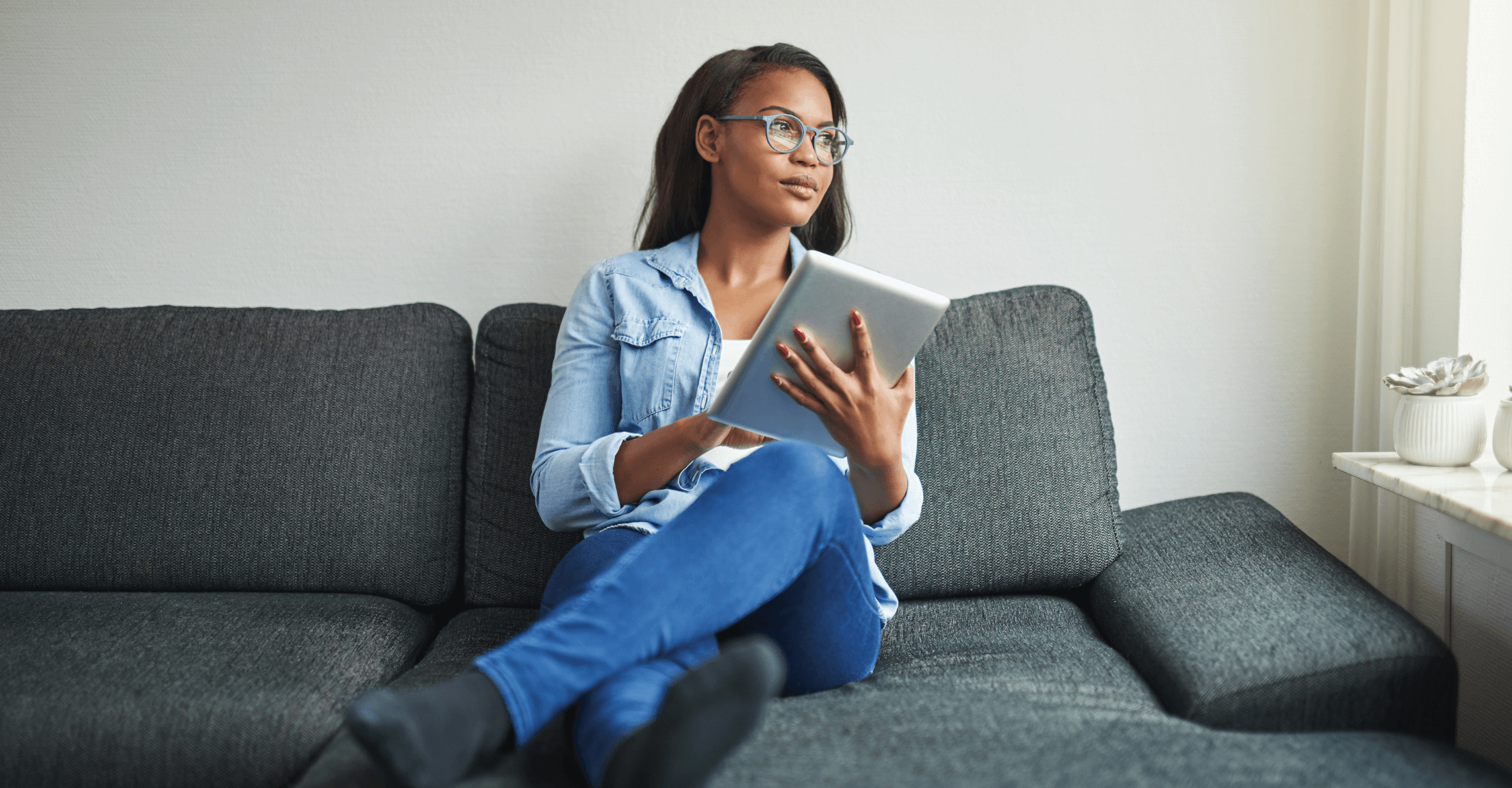 Woman sitting on a couch considering different financial planning software options